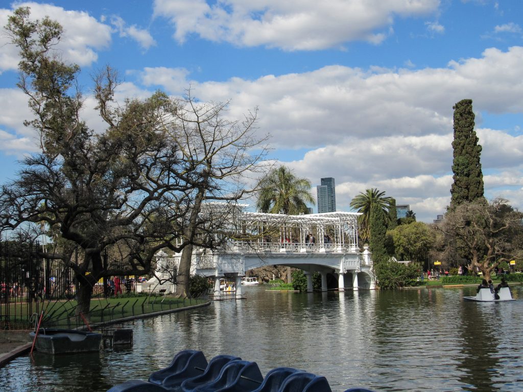 A lake, an ornate white bridge, and paddle boats in the Tres de Febrero park