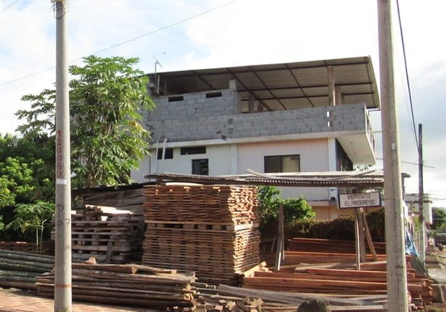 Piles of building materials in front of an unfinished building