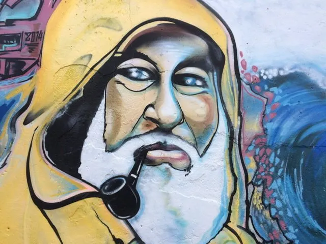 Mural of a fisherman in a yellow rain slicker smoking a pipe
