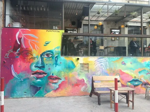 A fanciful face in bright colors painted on a wall