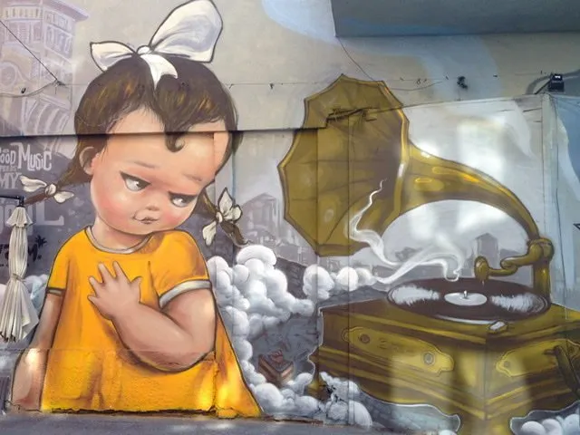 Mural of a young girl with pigtails giving side-eye to a gramophone