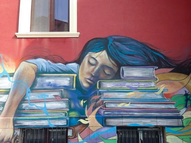 Mural of a girl asleep on a pile of books