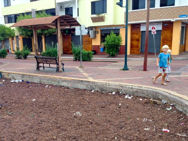 Two children walking by a litter-strewn lot