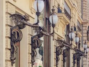 Six fauns holding lights on a building