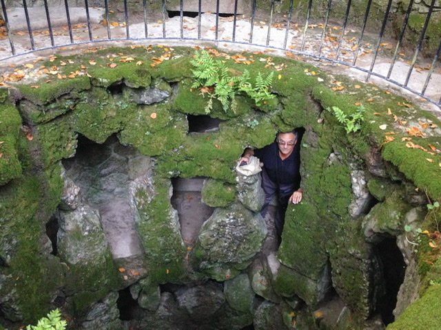 Man looking through a moss-covered opening