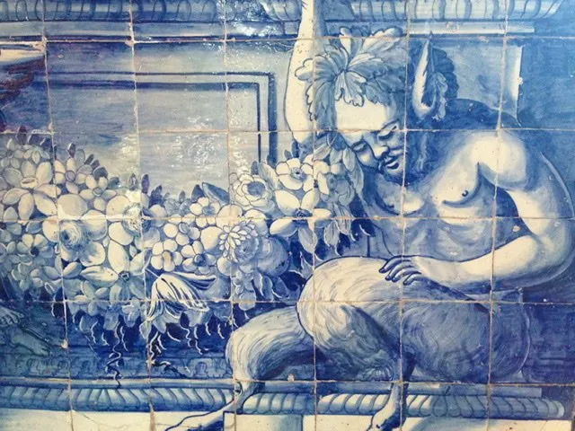 A close up of azulejo tiles featuring a faun and flowers