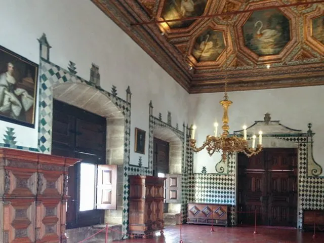 Room with partially tiled walls and swans painted on the ceiling