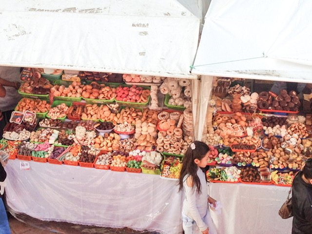 A girl walking by stands of sweets