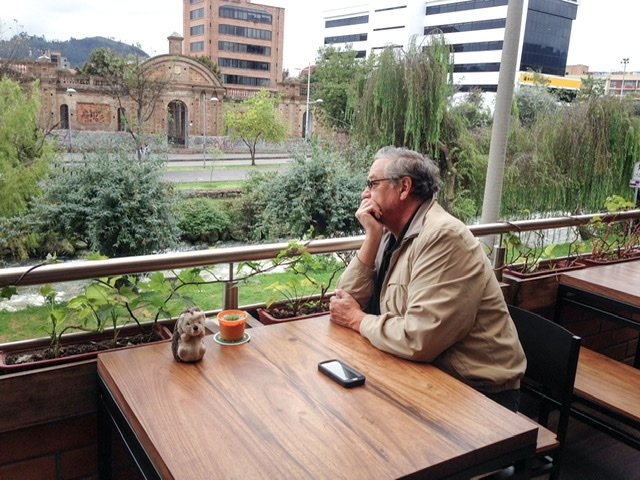 Man sitting at a table looking at a river