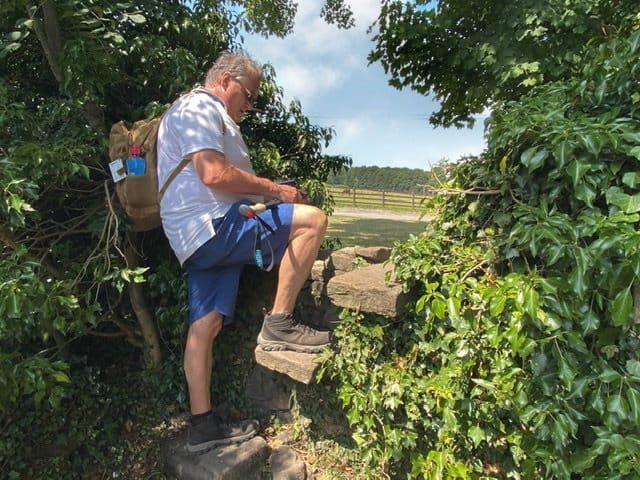 A man climbing a stile on the Dales Way