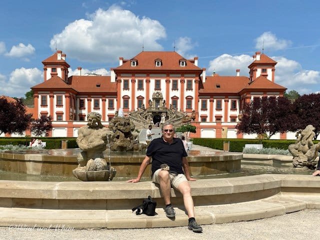 A man sitting in front of the Troja Chateau