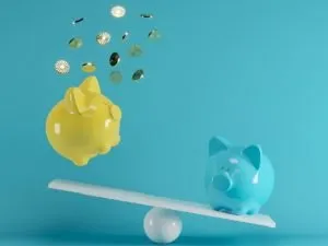 Two piggy banks on a seesaw