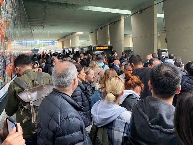 A large group of people waiting for a bus