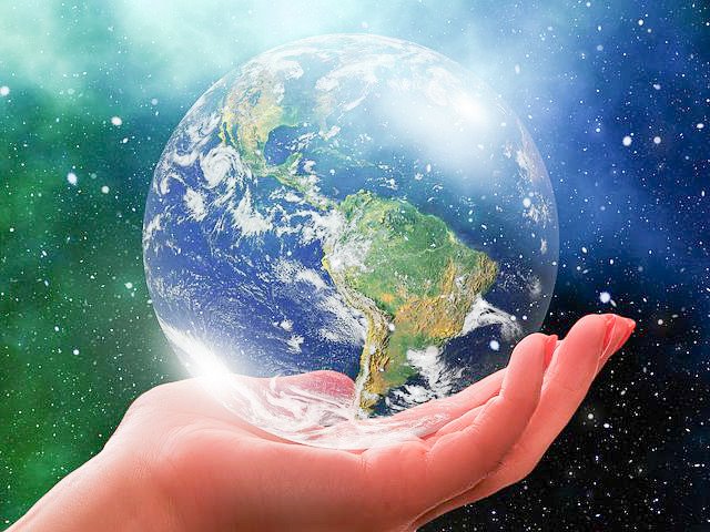 A hand holding a globe