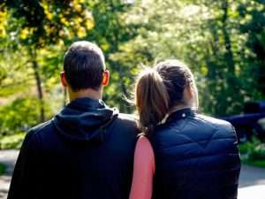 A man and woman walking through a park