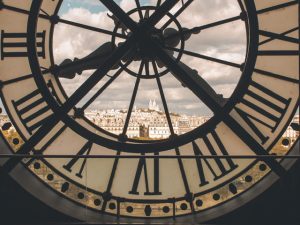 A large clock with a window overlooking Paris