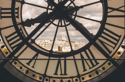 A large clock with a window overlooking Paris