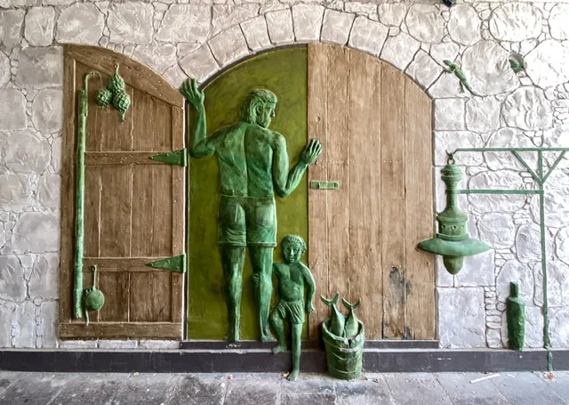 A relief of a man and a boy with freshly caught fish in a bucket
