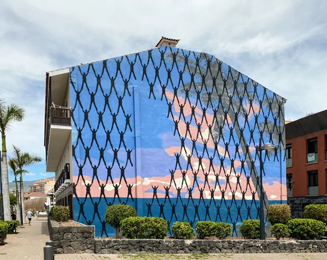A mural with human shapes standing on others’ shoulders