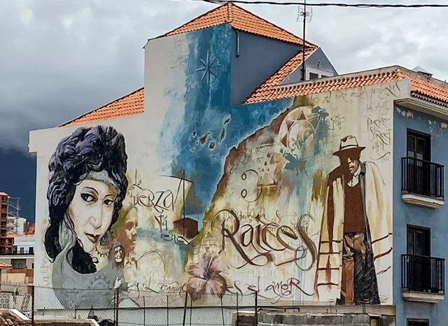 a wall with a painting of a woman’s head and a man