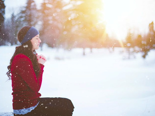 A woman praying in the snow