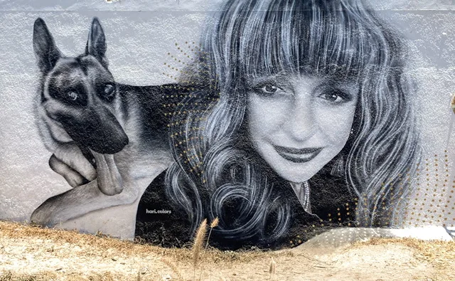 A mural of a woman and a German Shepherd