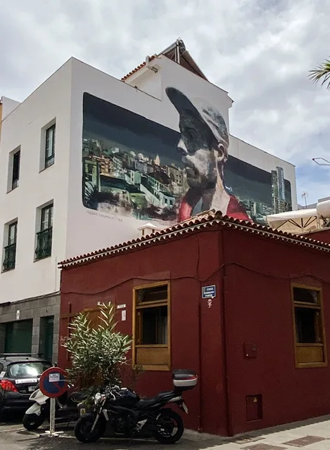 A mural of a man’s head and shoulders with a city in the background