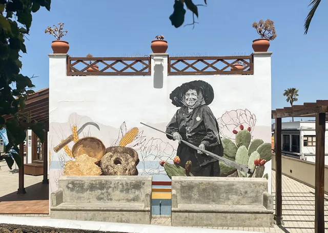 a mural of a woman holding a farm tool