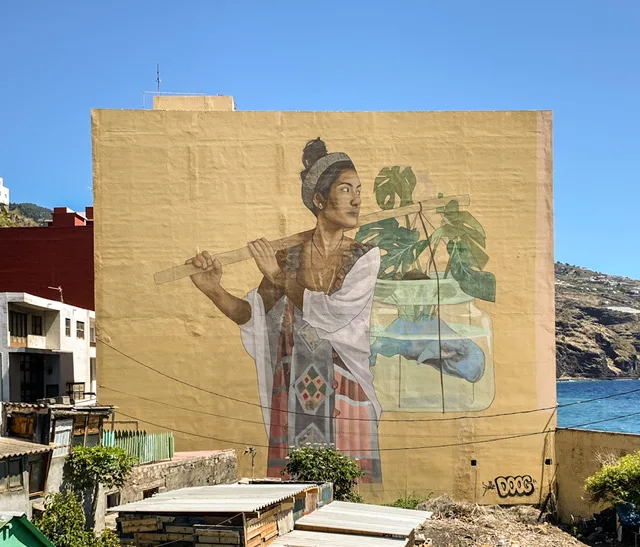 A mural of a woman carrying a large plant
