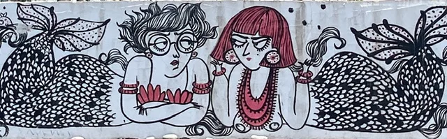 A mural of two funky mermaids