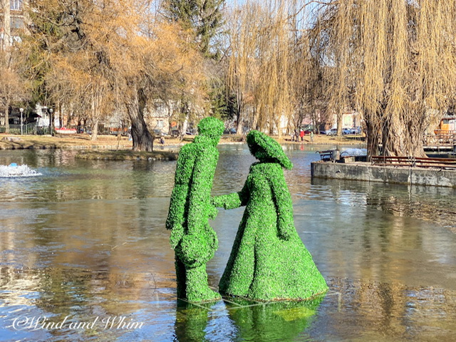 A topiary of a man and a woman in a pond