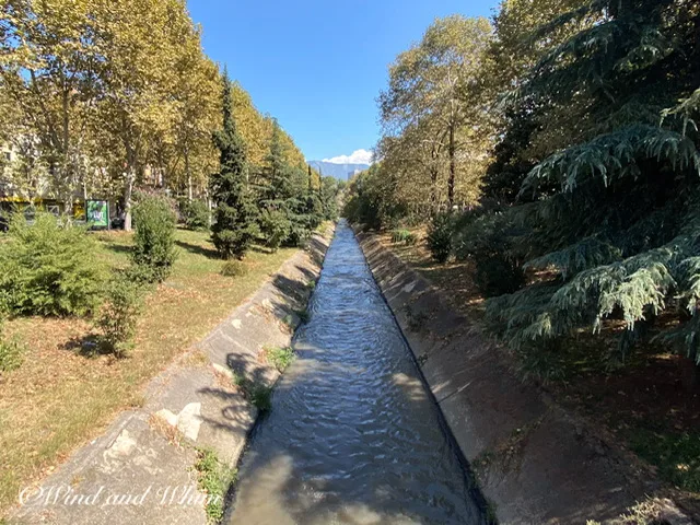 A narrow river lined with concrete banks