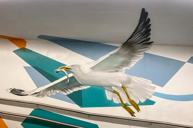 A mural of a seagull with food in his beak