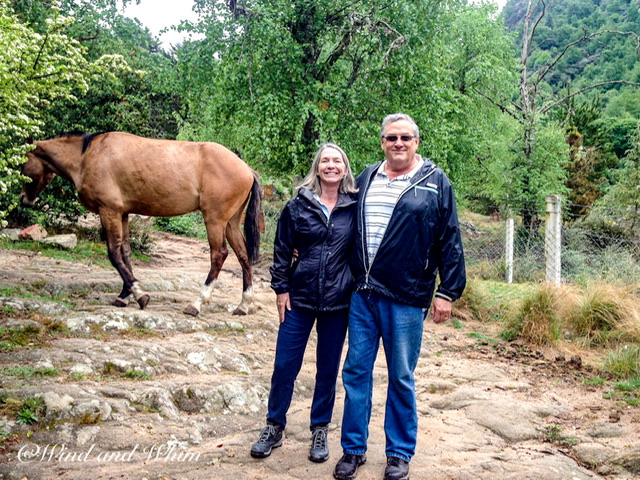 A man and a woman standing near a horse