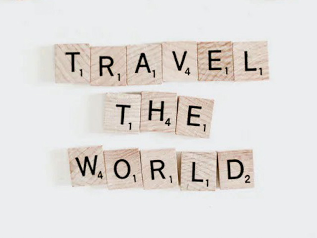 Scrabble tiles spelling out “travel the world”