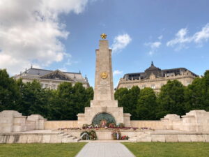 A memorial and two large buildings