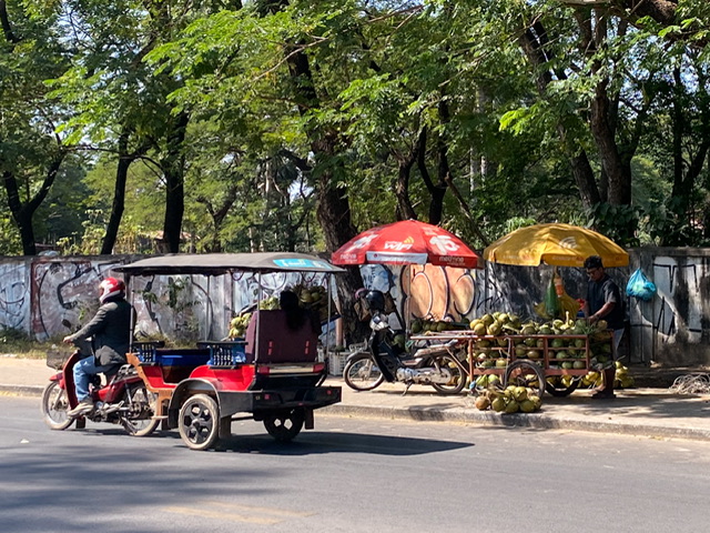 A tuk-tuk driving on a street