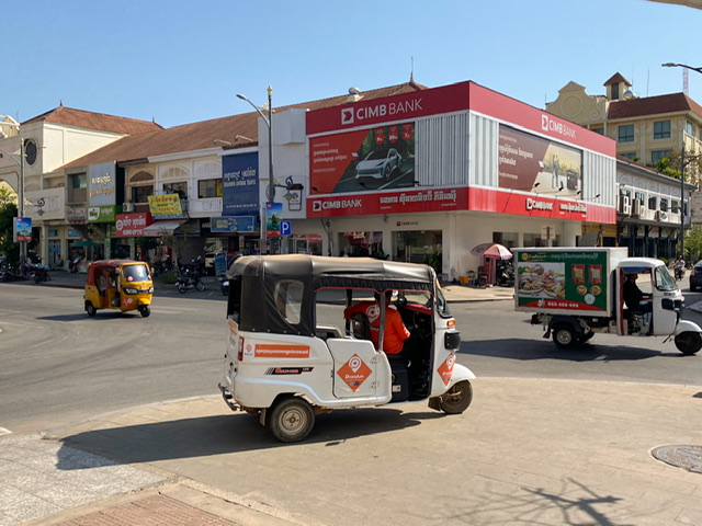 A tuk-tuk driving on a street