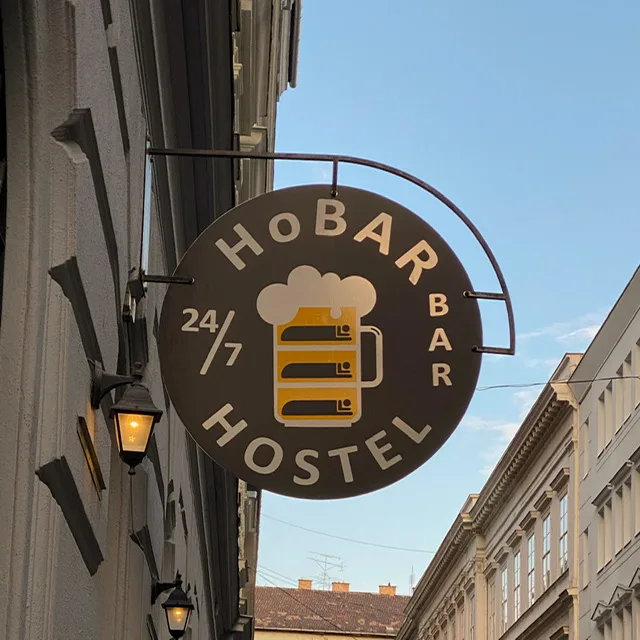 A sign on a hostel advertising a 24/7 bar
