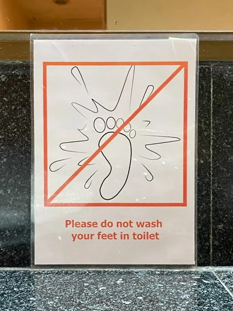 A sign telling the reader not to wash his feet in the toilet