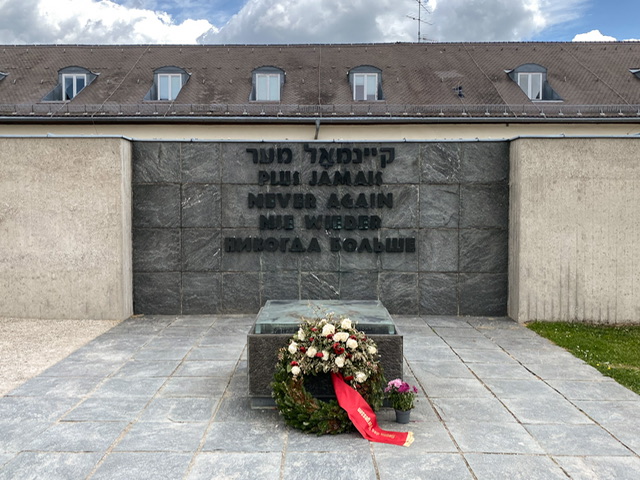 A wreath in front of a sign in multiple languages