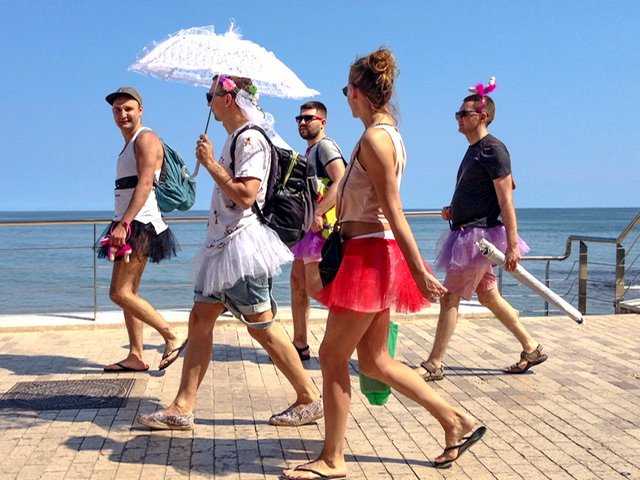 Five people in tutus on a boardwalk