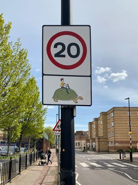 Street sign with 20 and a picture of a boy riding a turtle