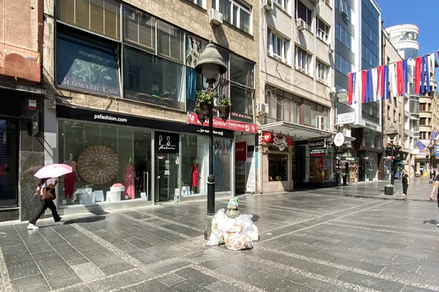 A nearly empty street with garbage near a lamp post