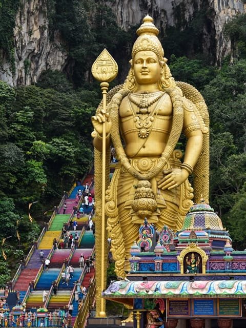 A tall golden statue in front of colorful stairs