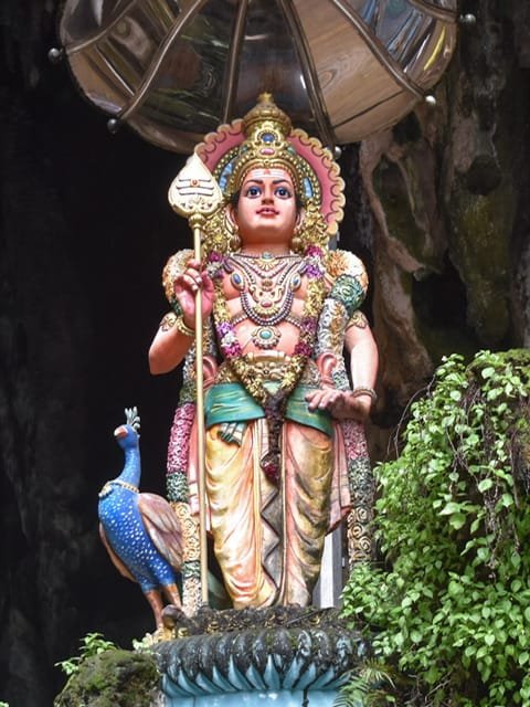 A statue of a Hindu goddess with a peacock