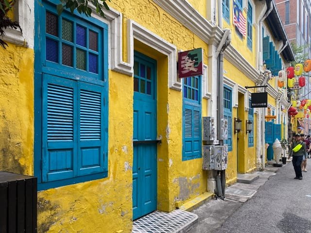 A row of bright yellow buildings with aqua trim