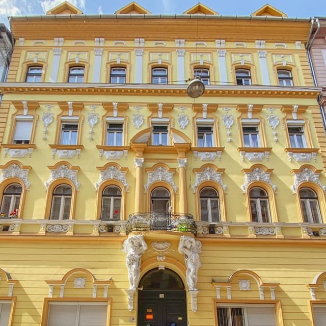 A bright yellow building with ornate white decorations