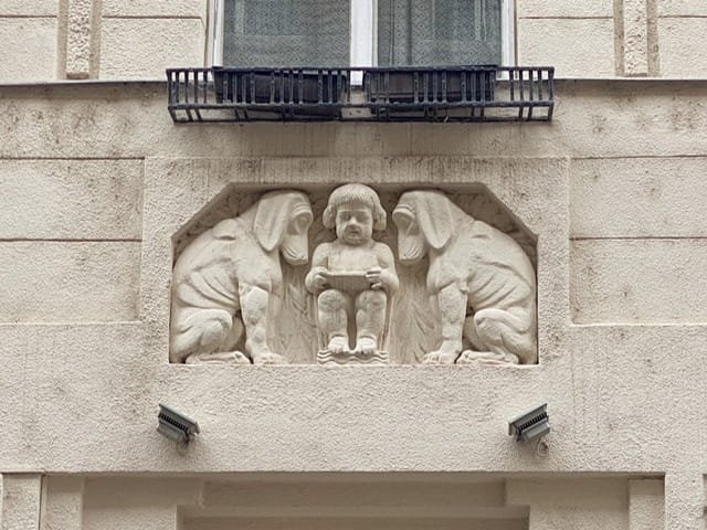 A relief with a small boy reading to two large dogs