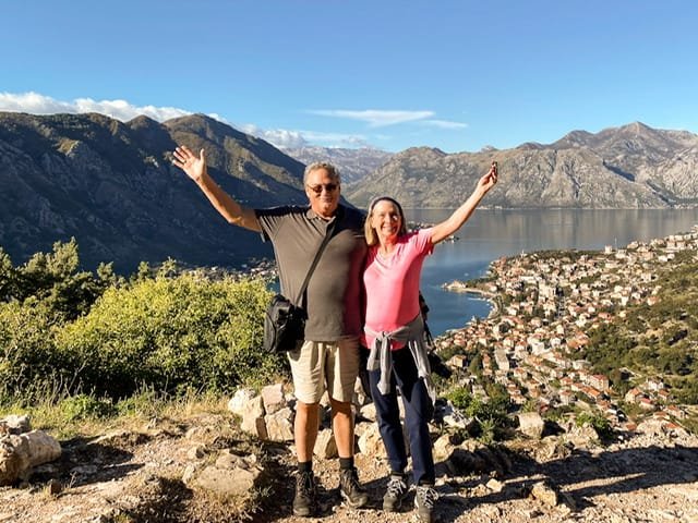 A man and a woman standing on a mountain